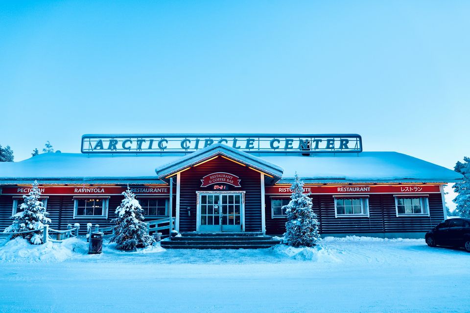 The Arctic Circle Center building at Santa Claus Village under a blue winter sky