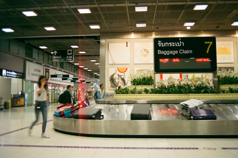 Passengers collecting luggage at an airport baggage carousel