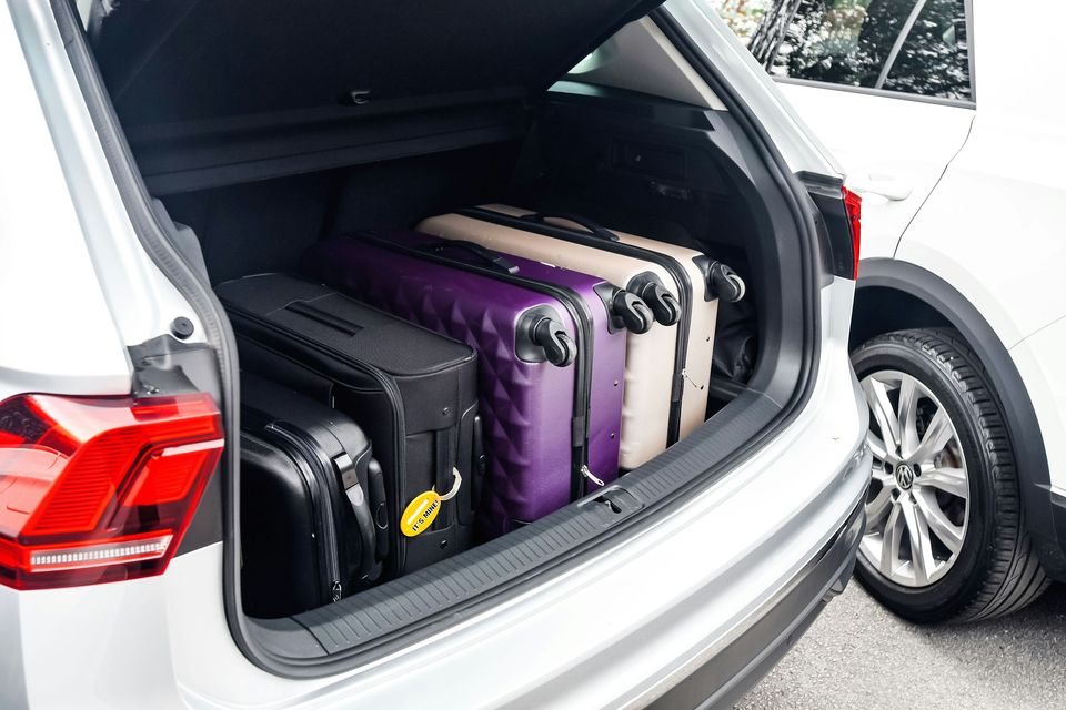 Suitcases packed into the open boot of a car
