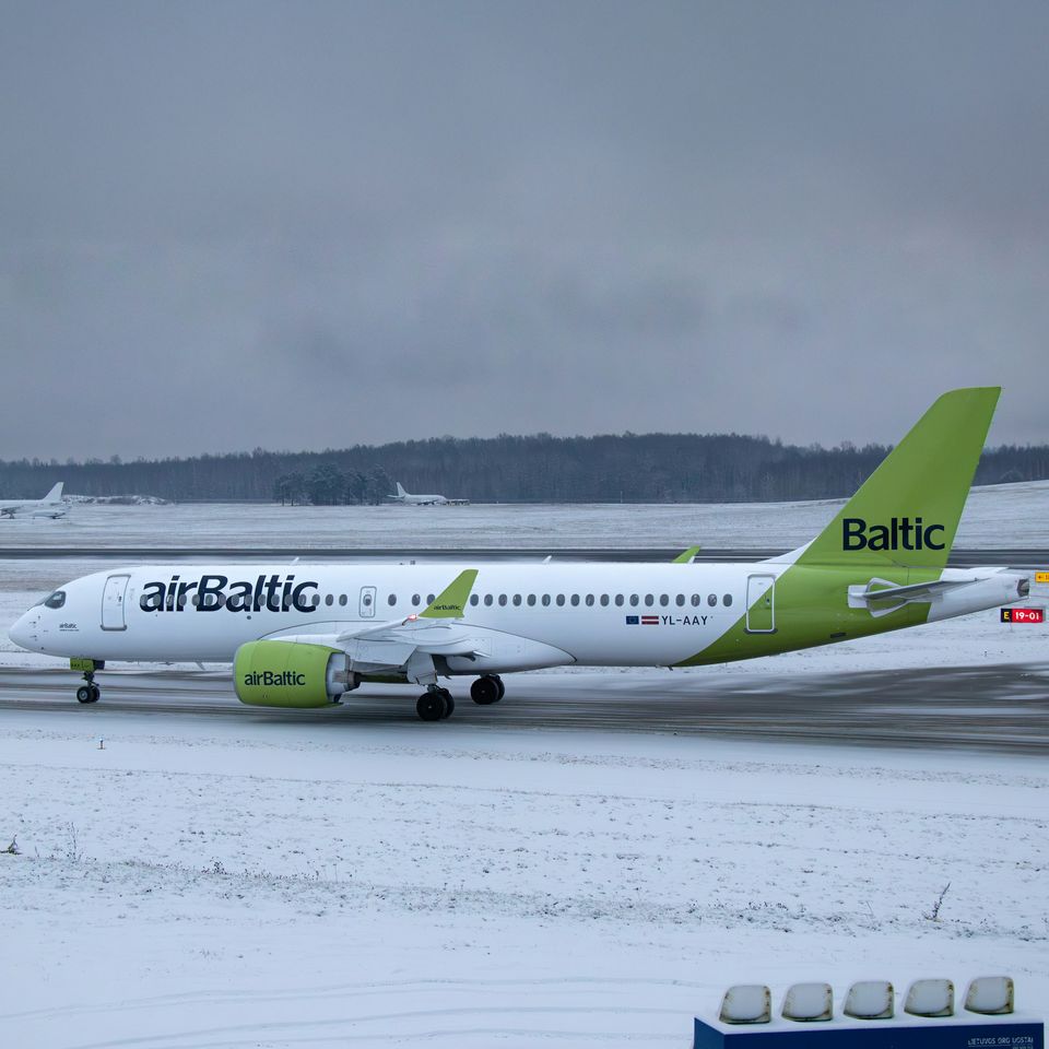 A passenger aircraft taxiing across a snow-covered airport apron