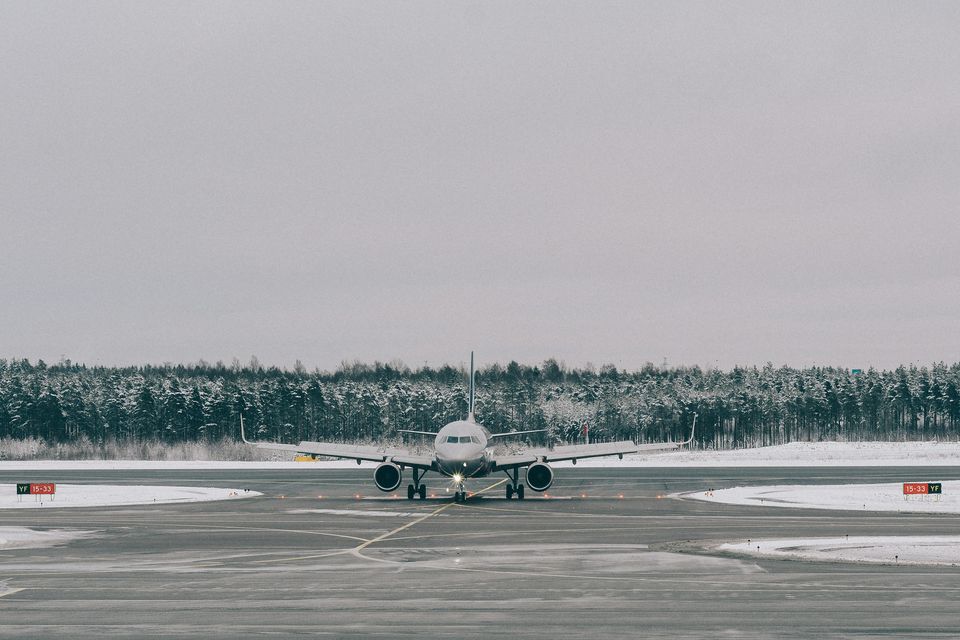 A passenger jet on a snow-lined runway on a misty winter day